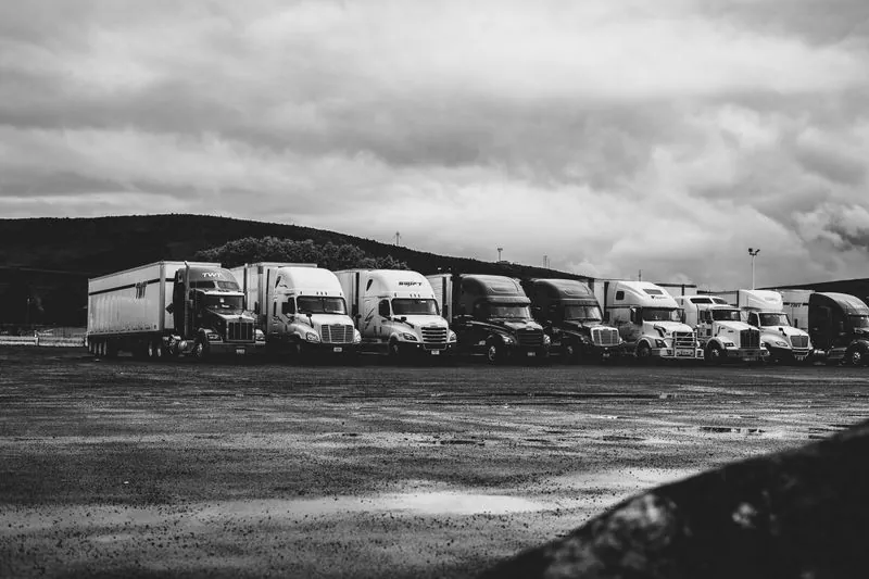 Row of commercial trucks in a fleet yard, trucking insurance